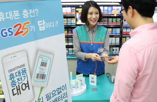 GS25 직원이 고객에게 보조배터리 충전 방법에 대해 설명하고 있다.  GS25 제공